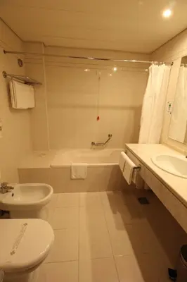 a bathroom with a tub and a toilet and a sink at Suite Hotel Jardins Da Ajuda in Funchal