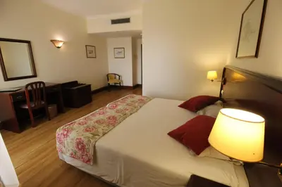a bedroom with a large bed with two lamps at Suite Hotel Jardins Da Ajuda in Funchal