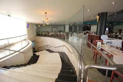 a staircase leading to a restaurant with tables and chairs at Suite Hotel Jardins Da Ajuda in Funchal