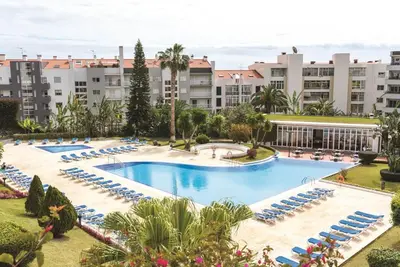 an overhead view of a large swimming pool with lounge chairs at Suite Hotel Jardins Da Ajuda in Funchal