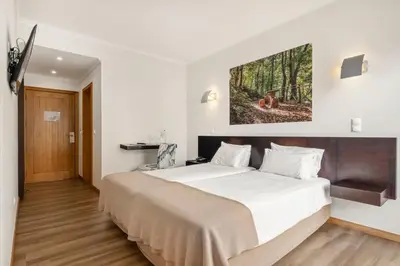 a bedroom with a large bed in a room at White Waters Hotel in Machico