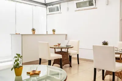 a dining room with white chairs and a table at White Waters Hotel in Machico