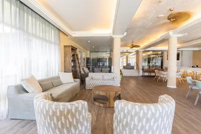 a lobby with a couch and chairs and a table at Vila Baleira Suites in Porto Santo