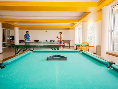 two people playing ping pong in a pool room at Vila Baleira Suites in Porto Santo