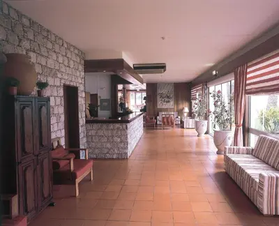 a lobby with a couch and chairs in a building at Hotel Praia Dourada in Porto Santo