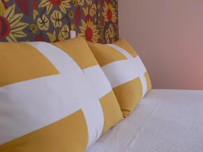 a bed with yellow and white pillows on it at Hotel Praia Dourada in Porto Santo