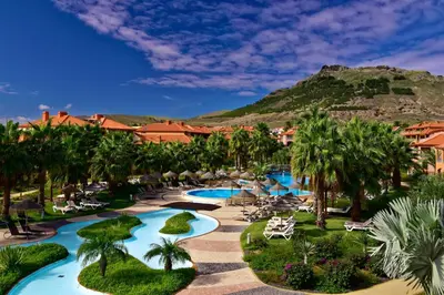 an aerial view of a resort with palm trees and pools at Pestana Porto Santo Premium All Inclusive Beach & SPA Resort in Porto Santo