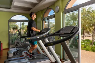 a man on a treadmill in a gym at Pestana Porto Santo Premium All Inclusive Beach & SPA Resort in Porto Santo
