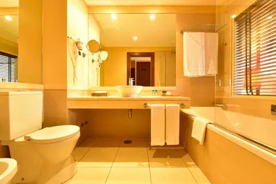 a bathroom with a toilet and a sink and a tub at Pestana Porto Santo Premium All Inclusive Beach & SPA Resort in Porto Santo