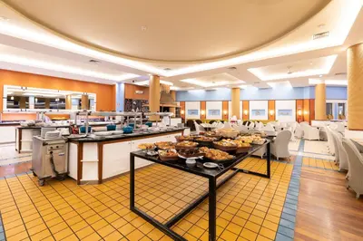 a buffet line with food on display in a cafeteria at Pestana Porto Santo Premium All Inclusive Beach & SPA Resort in Porto Santo