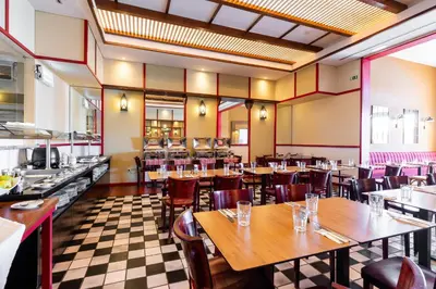 a restaurant with wooden tables and chairs and a checkered floor at Pestana Porto Santo Premium All Inclusive Beach & SPA Resort in Porto Santo