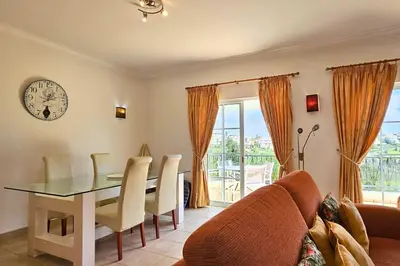 a dining room with a table and chairs and a clock at Quinta da Floresta – Santo António Villas, Golf & Spa in Budens