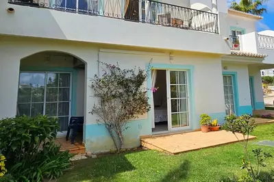a white house with a balcony and a yard at Quinta da Floresta – Santo António Villas, Golf & Spa in Budens