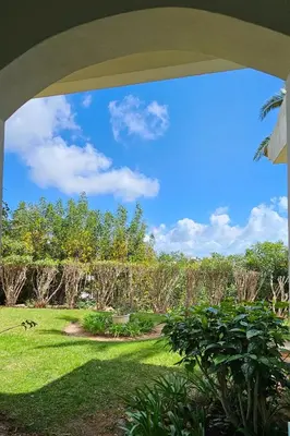 a view of a garden from an archway at Quinta da Floresta – Santo António Villas, Golf & Spa in Budens