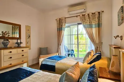 a bedroom with two beds and a window at Quinta da Floresta – Santo António Villas, Golf & Spa in Budens