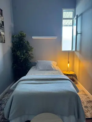 a bed in a room with a window and a lamp at Residencial Funchal in Funchal