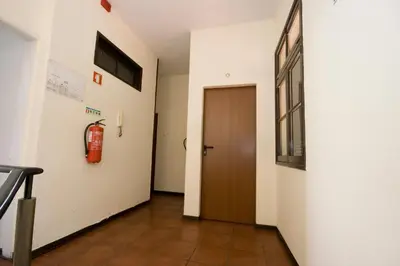 a hallway with a door and a fire extinguisher on the wall at Residencial Funchal in Funchal