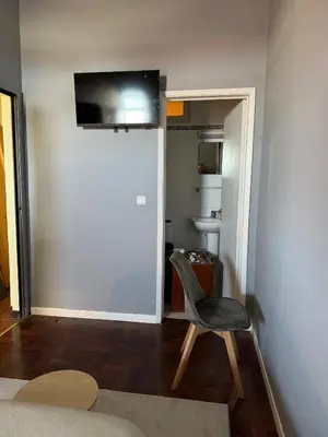 a room with a chair and a television on the wall at Residencial Funchal in Funchal