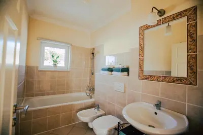 a bathroom with a sink and a toilet and a mirror at Casa do Pocinho in Raposeira