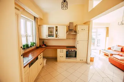 a large kitchen with white cabinets and a couch at Casa do Pocinho in Raposeira