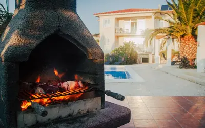 a stone oven with fire in front of a house at Casa do Pocinho in Raposeira