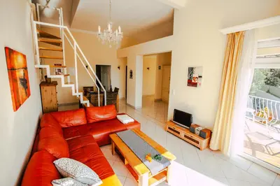 a living room with a red couch and a television at Casa do Pocinho in Raposeira
