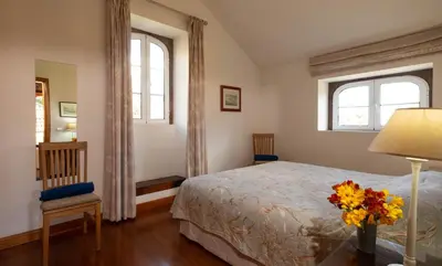 a bedroom with a bed and a vase of flowers on a table at OurMadeira - Casa do Feitor in Funchal