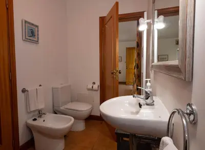 a white bathroom with a toilet and a sink at OurMadeira - Casa das Vinhas in Funchal