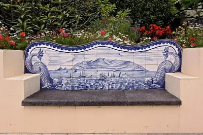 a blue and white bench sitting in a garden at OurMadeira - Loja da Lenha in Funchal