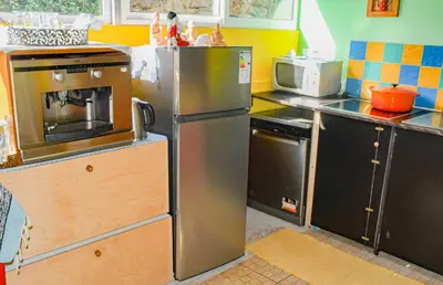a kitchen with a stainless steel refrigerator and a microwave at La Maison ZiaZen in Porto da Cruz