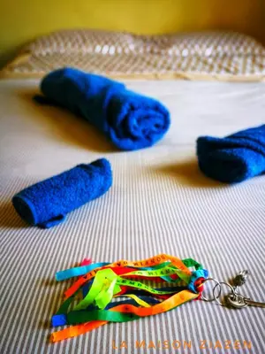 a toy bird on a bed with a pair of scissors at La Maison ZiaZen in Porto da Cruz