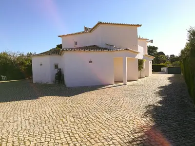a white house on a cobblestone street at Porto Mos Residence in Lagos