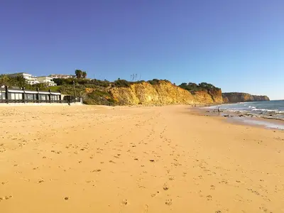 a beach with footprints in the sand and the ocean at Porto Mos Residence in Lagos
