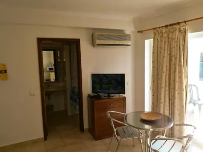 a living room with a table and a television at Porto Mos Residence in Lagos