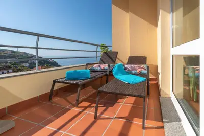 a balcony with two chairs and a table at Zeza´s apartament in Calheta