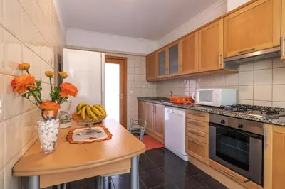 a kitchen with a table with a vase of flowers on it at Zeza´s apartament in Calheta