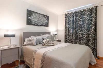 a bedroom with a large bed and a window at Zeza´s apartament in Calheta
