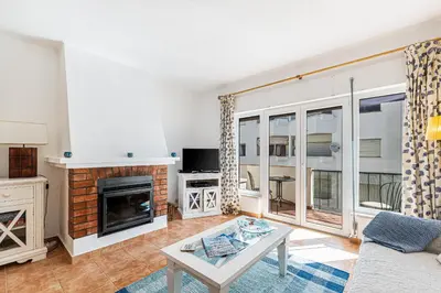 a living room with a fireplace and a tv at Casa do Coral - Praia da Luz in Luz
