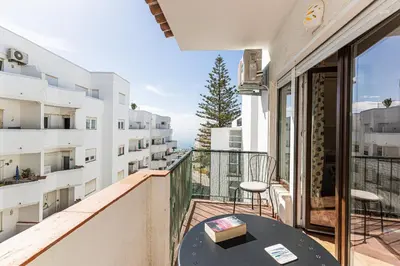 a balcony with a table and chairs on a building at Casa do Coral - Praia da Luz in Luz