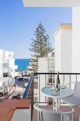 a table and chairs on a balcony with a view of the ocean at Casa do Coral - Praia da Luz in Luz