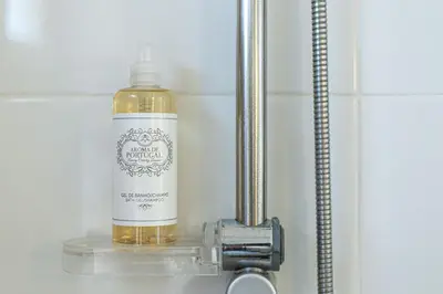 a bottle of oil sitting on a sink in a bathroom at Casa do Coral - Praia da Luz in Luz