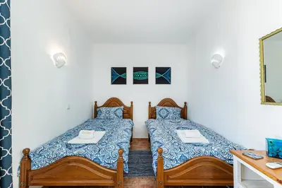 a bedroom with two beds and a desk at Casa do Coral - Praia da Luz in Luz