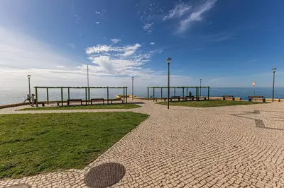 a park with benches and a view of the ocean at Casa do Coral - Praia da Luz in Luz