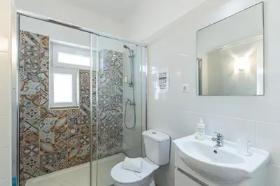 a bathroom with a toilet and a sink and a shower at Casa do Coral - Praia da Luz in Luz