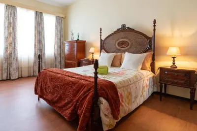 a bedroom with a large bed with a wooden headboard at Casa Fatima in Funchal