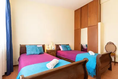 a bedroom with two beds with pink and blue sheets at Casa Fatima in Funchal