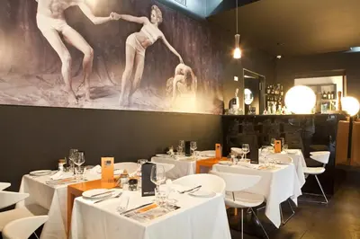 a restaurant with white tables and white chairs and a painting at Funchal Design Hotel in Funchal