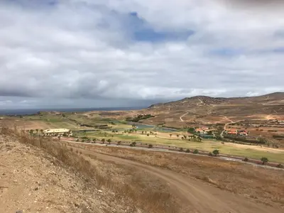 a dirt road in a field with mountains in the background at Duplex Ocean View in Porto Santo