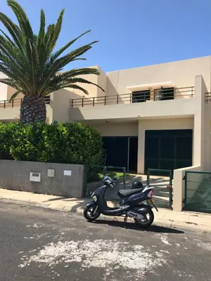 a scooter parked in a parking lot in front of a house at Duplex Ocean View in Porto Santo