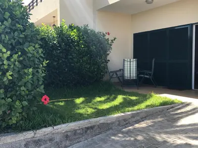a garden with a red flower in the grass at Duplex Ocean View in Porto Santo